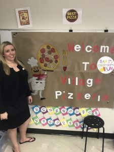 Picture of teacher dressed up as server in front of welcome background